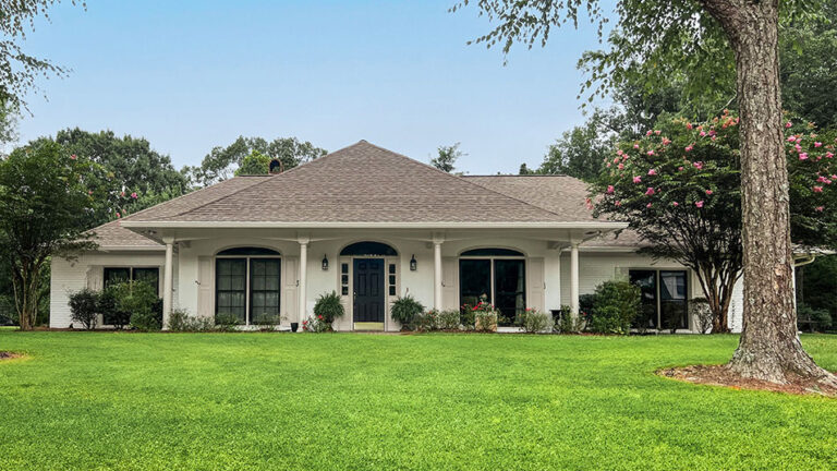 Ranch style home exterior with black windows